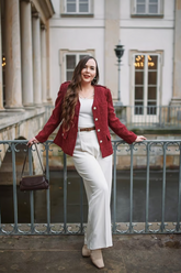 a lady wears a red tweed jacket with white suitpants